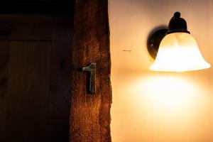 a light on the side of a wall with a lamp at Red Shutter Inn in Rossland +6 photos