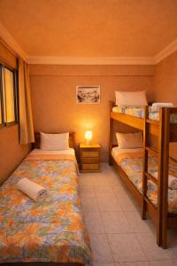 a bedroom with two bunk beds and a lamp at 2BR Luxury Apartment-Heart Of Taghazout, Private Beach Access, Panoramic View, Remote Work 100Mbps, Walk to Restaurants in Taghazout