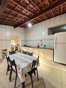 a kitchen with a table and chairs and a refrigerator at Sítio do Miguel in Barbacena