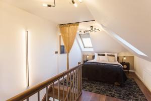 a attic bedroom with a bed and a staircase at Loft Gryfita - butikowy blisko plaży, 2-poziomowy in Szczecinek