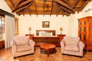 a living room with two chairs and a piano at Borinquen Thermal Resort in Liberia