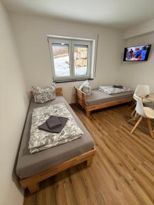 a room with two beds and a tv in it at Tiny Stay Guesthouse - Würzburg in Würzburg