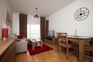 a kitchen and living room with a table and a couch at Apartment Butterfly in Osijek