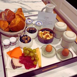 a tray of food with different types of bread and fruit at L'Écrin de la Sapinière in Merville +20 photos