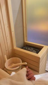 a person with their feet in a sauna with a bowl at Hotel Joli in San Marino