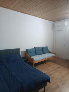 a bedroom with a blue bed and a couch at MTB b&b in Alfonsine