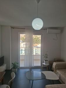 a living room with a table and a large window at Kevin&Elisa Your home! in Lezhë