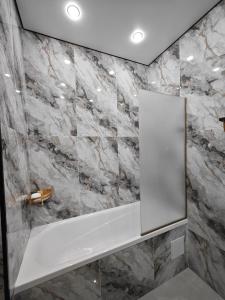 a bathroom with marble walls and a mirror at ЖК Central Park in Aktobe +47 photos