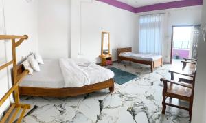 a bedroom with a large bed and a table at Juihal Residency & Kitchen in Kāziranga