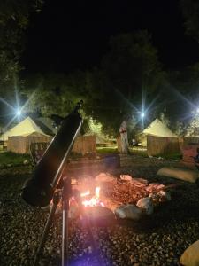 a fire pit in a yard at night at Ruina Glamping in Mezgit