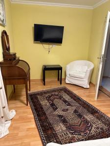 a living room with a flat screen tv on a wall at Gästeresidenz - Hotel - Ruthellen's Home in Planegg