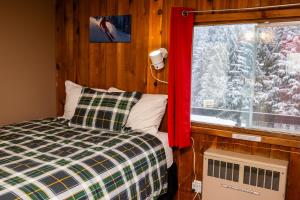 a bedroom with a bed and a window with snow at Red Shutter Inn in Rossland