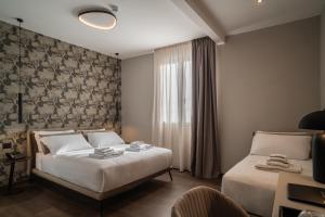 a hotel room with two beds and a window at Porpora Suite Hotel in Milan