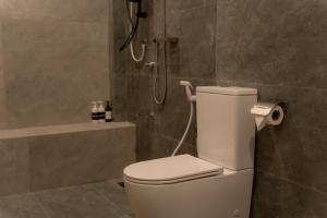 a bathroom with a white toilet and a shower at Orca Dickwella in Dickwella +64 photos