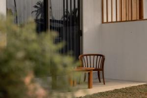 a wooden chair sitting in front of a door at Orca Dickwella in Dickwella