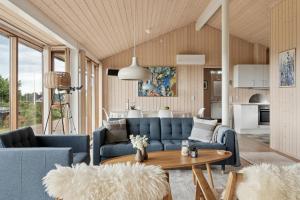 a living room with blue couches and a table at Seaside Cottage At Bønnerup Strand in Glesborg