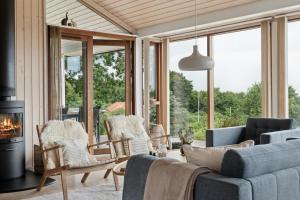 a living room with a couch and chairs and a fireplace at Seaside Cottage At Bønnerup Strand in Glesborg +29 photos