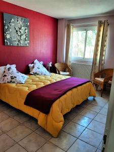 a bedroom with a large bed and a red wall at La Coscolleda Sorède in Sorède
