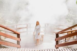 a woman in a white dress standing on a staircase at Borinquen Thermal Resort in Liberia