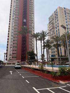 ein Auto, das auf einem Parkplatz mit hohen Gebäuden parkt in der Unterkunft Las Damas Piso18 in Benidorm