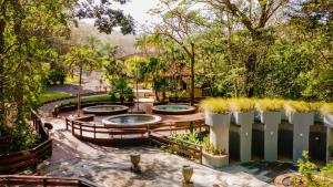 a garden with three pools and a fence at Borinquen Thermal Resort in Liberia +34 photos