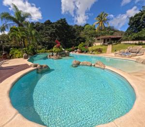 a swimming pool in a resort with blue water at Borinquen Thermal Resort in Liberia