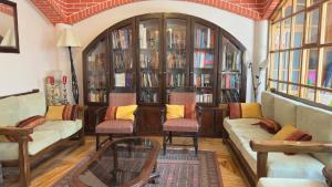 a living room with two couches and book shelves at Casa Elena in Cusco