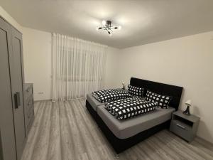 a bedroom with a bed with black and white pillows at Sofia2 in Urschmitt