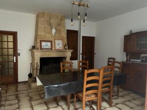 a dining room with a table and chairs and a fireplace at La petite maison in Rimaucourt