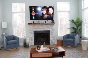 a living room with a fireplace with a flat screen tv at The Backwoods Paradise in Logan