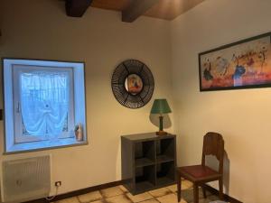 a living room with a chair and a window at La petite maison in Rimaucourt