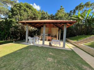 a gazebo with a table and chairs in a yard at Sítio do Miguel in Barbacena