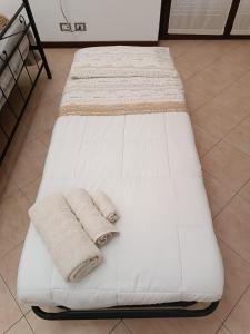 a white bed with two towels on it at AleGio Home in Zelo Buon Persico