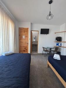 a bedroom with a bed and a table with a tableablish at Ravenala Paracas Hostel & Apartment in Paracas