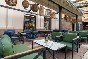 ein Restaurant mit grünen und blauen Stühlen und Tischen in der Unterkunft Zepter Spa Wellness Hotel & Zepterme member of Zepter Hotels in Vrnjačka Banja