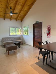 a room with tables and chairs and a couch at Treffen Cabañas in Villa General Belgrano