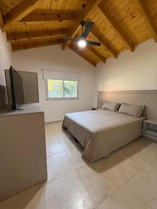 a bedroom with a bed and a flat screen tv at Treffen Cabañas in Villa General Belgrano +23 photos