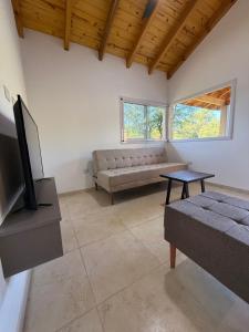 a living room with a couch and a tv at Treffen Cabañas in Villa General Belgrano