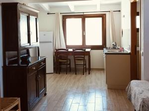a small room with a kitchen and a table with chairs at Dimora al parco in Domusnovas +26 photos