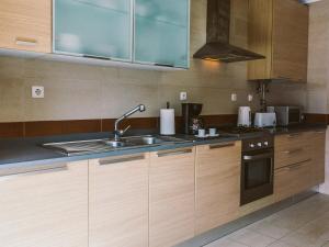 a kitchen with wooden cabinets and a sink at Central Caldas w/ AC & Fast Net in Caldas da Rainha +40 photos
