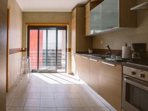 a kitchen with a large sliding glass door to a balcony at Central Caldas w/ AC & Fast Net in Caldas da Rainha