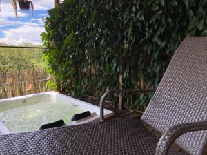 a chair and a hot tub on a balcony at Chalé Makar - Hidromassagem aquecida e vista para as montanhas in Serra do Cipo