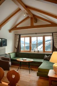 a living room with a green couch and a table at Brandhof in Ramsau am Dachstein