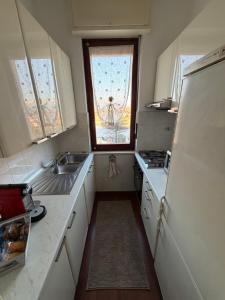a small kitchen with a sink and a window at La casa di Alice in Orbassano