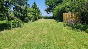 a field of grass with trees and a fence at Ciel Etoillè in Saint-Bonnet-de-Four +6 photos