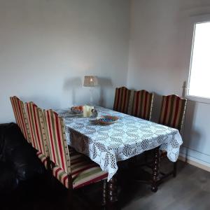 a dining room table with a table cloth and chairs at Ciel Etoillè in Saint-Bonnet-de-Four