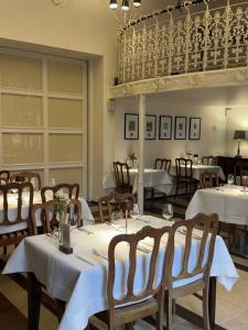 a dining room with tables and chairs with white tablecloths at Winnice Jaworek in Miękinia
