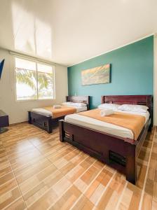 two beds in a room with blue walls and wooden floors at Kindia Park Hotel in La Esmeralda +43 photos