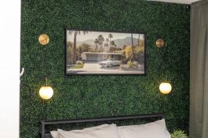 a wall covered in green plants with a picture on it at Quiet & Walkable - Stampede, BMO, Nightlife & Eats in Calgary