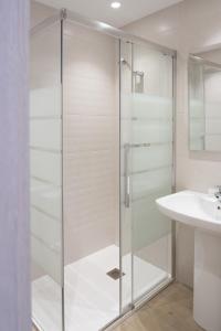 a glass shower door in a bathroom with a sink at Hotel La Cortijana in Logroño +18 photos